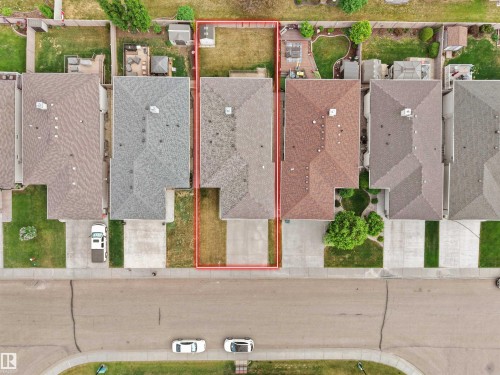Single-family residence with a gray shingle roof, concrete driveway, and a fenced backyard featuring a storage shed and a small patio area - 45 Willow Wood Lane, Stony Plain, AB 