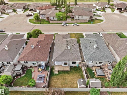 Aerial view showcasing a residential property with a shingled roof, a rear deck, and a fenced backyard - 45 Willow Wood Lane, Stony Plain, AB 
