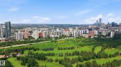 Expansive urban landscape featuring a central green space with mature trees and a golf course - 
