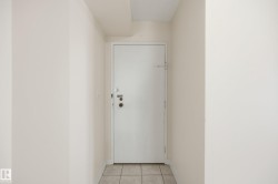 White entry door with multiple security locks, light beige wall paint, and square tile flooring - 
