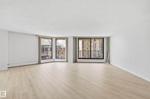 Spacious interior featuring light wood-finish flooring and white walls - 504 11710 100 Avenue, Edmonton, AB 