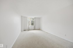 Bright room featuring light-toned carpet flooring, white walls, and a window with white trim - 
