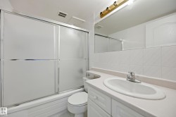 Bathroom featuring a white vanity with an integrated sink, chrome faucet, and a large mirror - 