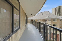 Expansive balcony featuring a gray concrete surface, black metal railings, and a light-colored stucco exterior - 