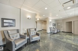 Expansive common area featuring green marble-finish flooring, textured wall coverings, and recessed ceiling lighting - 