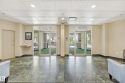 Lobby area featuring large format green marble-look tile flooring and a contrasting dark baseboard - 