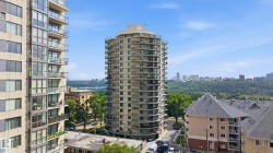High-rise residential building featuring multiple private balconies with dark railings and glass panels - 