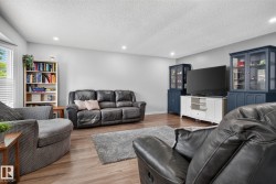 Spacious living area featuring wood-finish flooring, recessed lighting, and light-toned walls - 