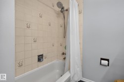 Bathroom tub and shower combination featuring decorative wall tiling - 