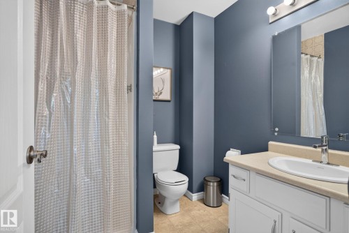 Bathroom featuring a white vanity with a light-colored countertop, an undermount sink, and chrome fixtures - 3218 41 Street, Leduc, AB 