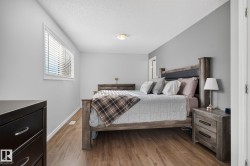 Bedroom featuring wood-finish flooring, light gray wall paint, and white trim - 