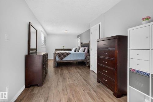 Spacious room with wood-finish flooring, light gray wall paint, and a built-in window with horizontal blinds - 3218 41 Street, Leduc, AB 