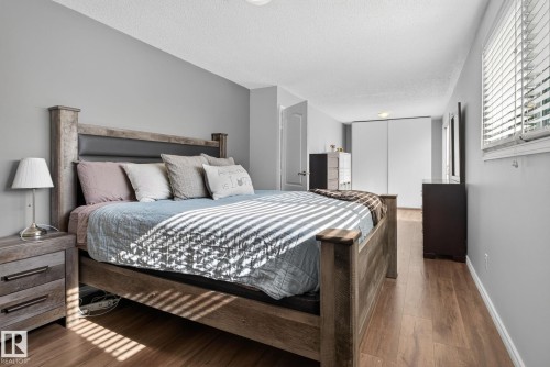 Bedroom featuring wood-finish flooring, light gray wall paint, and white trim - 3218 41 Street, Leduc, AB 