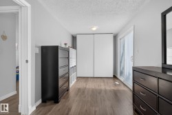 Spacious room featuring wood-finish flooring, light gray walls, and white trim - 