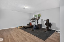 Spacious room featuring wood-finish flooring, light gray walls, white trim, and a white ceiling - 