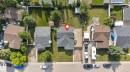 Aerial view of a residential property featuring a paved driveway, a large rear yard with a patio, mature trees, and a shingle roof - 3218 41 Street, Leduc, AB 