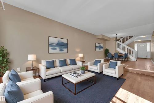 Living area featuring a spacious layout, wood-finish flooring, and neutral wall tones - 6632 36A Avenue, Edmonton, AB 