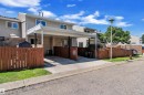 Exterior featuring light-toned horizontal siding, a covered car port, brown fencing, and a manicured lawn area - 6632 36A Avenue, Edmonton, AB 