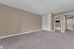 Spacious room with neutral wall color and grey carpet flooring - 