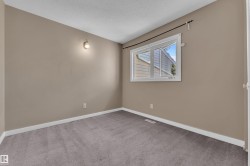 Neutral-toned walls complementing gray carpeting, white trim, and a white-framed window - 