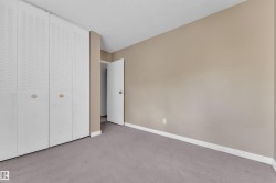 Wall-to-wall carpeting with white baseboards, textured ceiling, and light beige wall paint - 