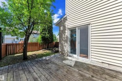 Expansive wood deck with a sliding glass door entry to the interior, featuring horizontal siding - 
