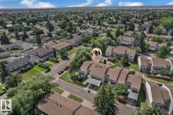 Aerial perspective showcasing residential properties with light-colored siding and sloped brown roofs - 
