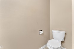 White toilet with a chrome toilet paper holder - 