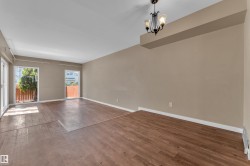 Spacious room featuring wood-finish flooring, neutral-toned walls, and multiple sliding glass doors - 
