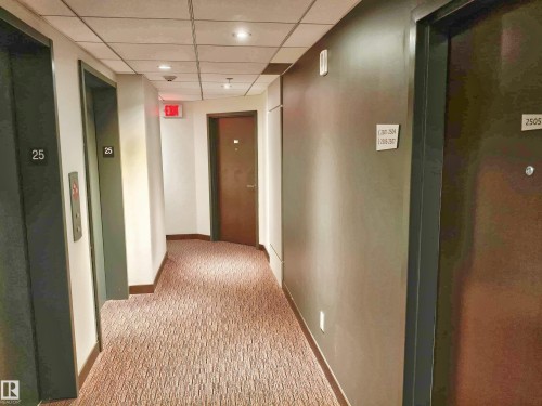 Residential hallway featuring patterned carpeting, recessed lighting, and individual unit doors - 2505 10410 102 Avenue, Edmonton, AB 