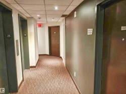 Residential hallway featuring patterned carpeting, recessed lighting, and individual unit doors - 
