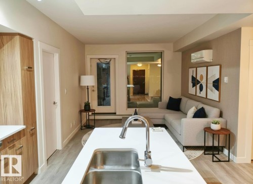 Kitchen island with an undermount stainless steel sink and a chrome pull-down faucet - 2505 10410 102 Avenue, Edmonton, AB 