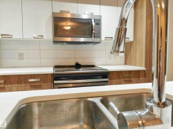 Stainless steel sink and chrome faucet with white solid surface countertops - 