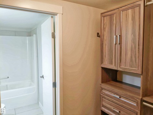 Custom built-in storage system with wood-finish cabinetry and brushed nickel hardware - 2505 10410 102 Avenue, Edmonton, AB 