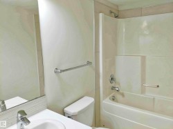 Bathroom featuring a white vanity with an integrated sink, chrome faucet, and a subway tile backsplash - 