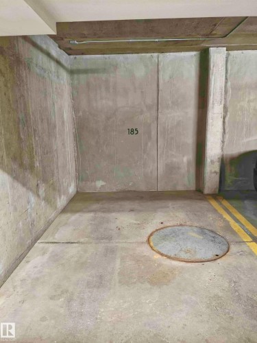 Concrete walled parking space featuring painted numerical designation, concrete flooring, and yellow stripe markings - 2505 10410 102 Avenue, Edmonton, AB 