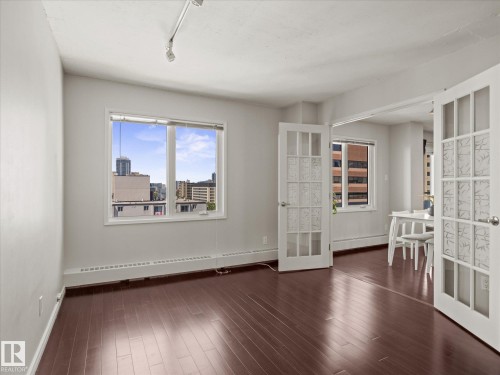 Spacious interior featuring rich wood-finish flooring and track lighting - 1601 9725 106 Street, Edmonton, AB 