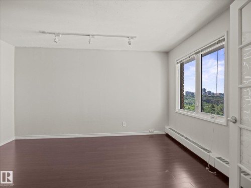 Bright interior space featuring a large window with city and green space scenery - 1601 9725 106 Street, Edmonton, AB 