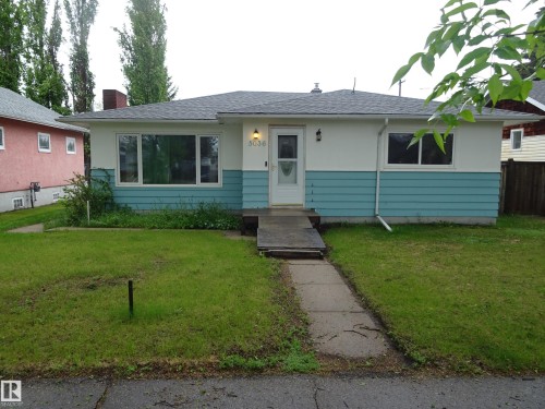 Ranch-style residence featuring a prominent front entrance, multiple windows, and a concrete walkway - 5036 52 Street, Andrew, AB 