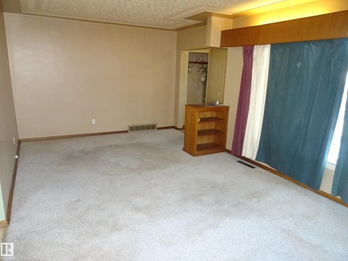 Wall-to-wall carpeting in a neutral tone complements the light-colored walls - 5036 52 Street, Andrew, AB 