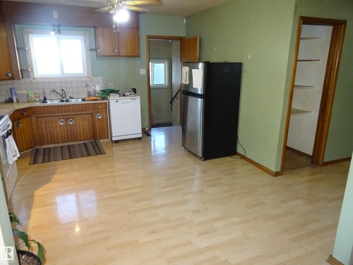 Kitchen featuring light wood-finish flooring and sage green walls - 5036 52 Street, Andrew, AB 