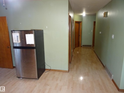 Light wood-finish flooring extending through the space - 5036 52 Street, Andrew, AB 