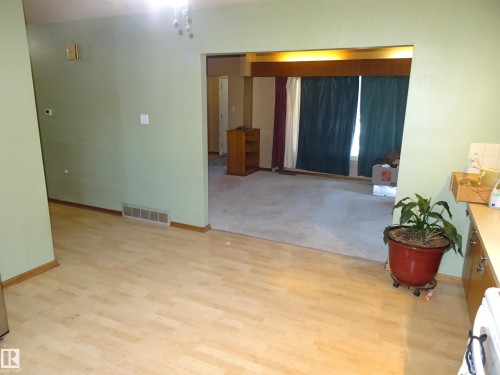 Light wood-finish flooring in an open concept living area - 5036 52 Street, Andrew, AB 