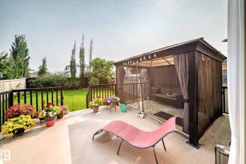 Outdoor patio featuring light-toned decking, black railings, and a screened gazebo - 8507 179 Avenue, Edmonton, AB 