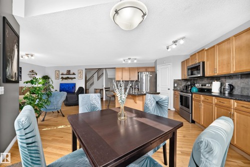 Dining area with wood-finish flooring, featuring a dark-toned table - 8507 179 Avenue, Edmonton, AB 
