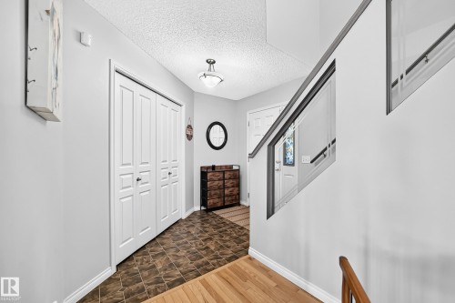 Entryway featuring bifold closet doors, patterned tile flooring, and a contemporary ceiling light fixture - 8507 179 Avenue, Edmonton, AB 