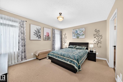 Carpeted bedroom featuring neutral wall tones and a ceiling-mounted light fixture - 8507 179 Avenue, Edmonton, AB 