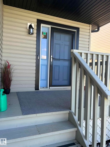 Covered front porch with wood-finish steps and railing - 8507 179 Avenue, Edmonton, AB 