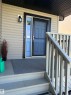 Covered front porch with wood-finish steps and railing - 8507 179 Avenue, Edmonton, AB 