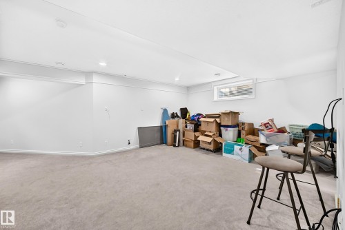 Spacious room featuring light carpeting, white walls, recessed lighting, and a white ceiling with crown molding - 8507 179 Avenue, Edmonton, AB 